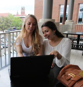 Female students using laptop outside