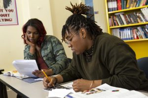 PHOTO: Non-binary student taking notes in class