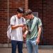 PHOTO: Two male students look at a smartphone on campus