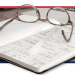 GRAPHIC: Photo of notebook containing formulas, with a pair of glasses laying on top.