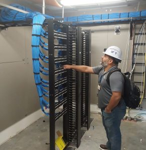 PHOTO: UFIT Core team employee inspecting wiring in new Student Health Care Center. University of Florida