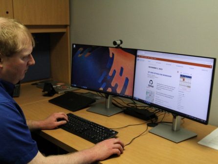 PHOTO: Male staff member working at his desktop PC in the New Physics Building. University of Florida.